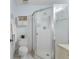 Bathroom featuring a corner shower with a glass door, a toilet and a shelf on the wall at 25100 Sandhill Blvd # R202, Punta Gorda, FL 33983