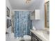 Bathroom featuring shower-tub combo, sea shell curtain and brown vanity at 25100 Sandhill Blvd # R202, Punta Gorda, FL 33983