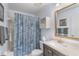 Bathroom featuring shower-tub combo, sea shell curtain and brown vanity at 25100 Sandhill Blvd # R202, Punta Gorda, FL 33983