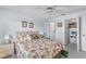 Bright bedroom with queen bed and floral print, ceiling fan, side table and closet with white doors at 25100 Sandhill Blvd # R202, Punta Gorda, FL 33983