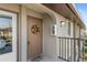 Condo front door with wreath, welcome mat, neutral paint, and black metal railing at 25100 Sandhill Blvd # R202, Punta Gorda, FL 33983