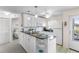 Bright kitchen with white cabinets, black granite countertops, modern appliances, and adjacent bedroom view at 25100 Sandhill Blvd # R202, Punta Gorda, FL 33983