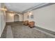 Carpeted hallway with chairs and framed artwork in neutral colors at 25188 Marion Ave # A206, Punta Gorda, FL 33950