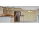 Bright kitchen featuring stainless steel refrigerator and granite countertops at 25188 Marion Ave # A206, Punta Gorda, FL 33950