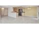 Spacious living room featuring tile floors that transition to a modern kitchen with stainless steel appliances at 25188 Marion Ave # A206, Punta Gorda, FL 33950