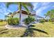 The back exterior features an upper deck, screened enclosure, tropical landscaping, and manicured backyard at 2718 Saint Thomas Dr, Punta Gorda, FL 33950