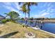 A spacious backyard with mature palm trees leads to a private boat dock and lift on a picturesque canal at 2718 Saint Thomas Dr, Punta Gorda, FL 33950