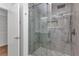 Beautiful glass-enclosed shower features neutral-toned tile, a rainfall shower head, and convenient built-in shelving at 2718 Saint Thomas Dr, Punta Gorda, FL 33950