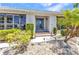 Inviting front entrance with a decorative glass door, white gravel landscaping, and manicured greenery at 2718 Saint Thomas Dr, Punta Gorda, FL 33950