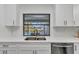 Bright kitchen featuring white cabinetry, stainless steel sink, and window view of the pool at 2718 Saint Thomas Dr, Punta Gorda, FL 33950