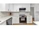 Updated kitchen showcases white cabinets, marble backsplash, and stainless steel appliances at 2718 Saint Thomas Dr, Punta Gorda, FL 33950