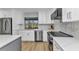 Gourmet kitchen with stainless steel appliances, white cabinetry, marble backsplash, and under-cabinet lighting at 2718 Saint Thomas Dr, Punta Gorda, FL 33950