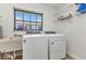 Bright laundry room featuring white washer and dryer, a utility sink, and a window providing natural light at 2718 Saint Thomas Dr, Punta Gorda, FL 33950