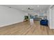 Open-concept living room with wood-look floors, leading into an open kitchen with views of a screened-in pool at 2718 Saint Thomas Dr, Punta Gorda, FL 33950