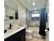Modern bathroom with a combo tub and shower, attractive gray tile, and sleek black hardware at 3324 Port Charlotte Blvd, Port Charlotte, FL 33952