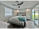 Comfortable bedroom with soft lighting, a sliding glass door, a decorative bench, and a ceiling fan at 3324 Port Charlotte Blvd, Port Charlotte, FL 33952