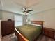 Cozy bedroom with wood furniture, ceiling fan, and a large window for natural light at 3324 Port Charlotte Blvd, Port Charlotte, FL 33952