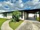 Beautiful home exterior featuring a well-kept yard, modern carport, and fresh landscaping for inviting curb appeal at 3324 Port Charlotte Blvd, Port Charlotte, FL 33952