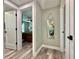 Hallway with gray walls, white trim and doors, wood-look flooring, and a stylish mirror at 3324 Port Charlotte Blvd, Port Charlotte, FL 33952