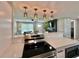 Open-concept kitchen with stainless steel appliances, quartz countertops, and stylish pendant lighting above the island at 3324 Port Charlotte Blvd, Port Charlotte, FL 33952