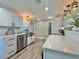 Bright kitchen with white cabinets, stainless steel appliances, and a large sink with modern fixtures at 3324 Port Charlotte Blvd, Port Charlotte, FL 33952