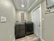 Laundry room featuring gray washer and dryer, neutral walls, and white door at 3324 Port Charlotte Blvd, Port Charlotte, FL 33952