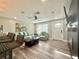 Open concept living room featuring a sleek television, modern ceiling fan, and stylish, neutral decor perfect for entertaining at 3324 Port Charlotte Blvd, Port Charlotte, FL 33952