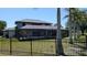 Fenced backyard featuring a screened-in patio perfect for entertaining, tall palms, and a well-maintained lawn at 384 Viedma St, Punta Gorda, FL 33983