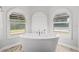 A close up shot of a soaking tub in front of three arched windows at 384 Viedma St, Punta Gorda, FL 33983