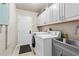 Well-lit laundry room with washer, dryer, sink, and storage cabinets at 384 Viedma St, Punta Gorda, FL 33983