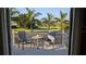 Outdoor patio with a table and chairs overlooking lush greenery and mature palm trees at 384 Viedma St, Punta Gorda, FL 33983