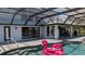 Inviting backyard pool featuring an inflatable flamingo under a screened-in lanai with outdoor kitchen at 384 Viedma St, Punta Gorda, FL 33983