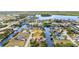 Expansive aerial view of the waterfront community with a single-Gathering home, boat dock, and lush landscaping at 4473 Sweetbay St, Port Charlotte, FL 33948