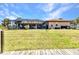 Backyard view of a screened-in pool, patio, and lush green lawn extending to the waterfront at 4473 Sweetbay St, Port Charlotte, FL 33948