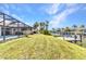 Spacious backyard featuring a screened-in pool, lush landscaping, and a private dock on the canal at 4473 Sweetbay St, Port Charlotte, FL 33948