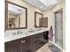 Bathroom featuring double sinks, marble countertops, a walk-in shower, and framed mirrors at 4473 Sweetbay St, Port Charlotte, FL 33948