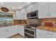 Bright kitchen featuring white cabinetry, stainless steel appliances, and stylish backsplash at 4473 Sweetbay St, Port Charlotte, FL 33948