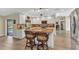 Open kitchen with island seating, stainless appliances, white cabinets, and wood flooring at 4473 Sweetbay St, Port Charlotte, FL 33948