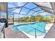 Beautiful pool area with a screened enclosure, offering a serene view of the canal and surrounding greenery at 4473 Sweetbay St, Port Charlotte, FL 33948