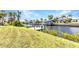 Picturesque waterfront property featuring a private dock and lush green lawn, perfect for outdoor enjoyment at 4473 Sweetbay St, Port Charlotte, FL 33948