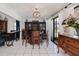 Well-lit bar area with wooden bar, blue bar stools, and dark wood cabinets under a decorative chandelier at 5061 San Rocco Ct, Punta Gorda, FL 33950