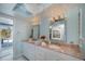 Bright bathroom with double vanities, pink granite countertop and access to the outdoors at 5061 San Rocco Ct, Punta Gorda, FL 33950