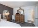 Well-lit bedroom with a dresser, mirror, and doorway leading to the bathroom at 5061 San Rocco Ct, Punta Gorda, FL 33950