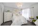 Bright bedroom featuring a chandelier, dresser, and white linens with decorative pillows at 5061 San Rocco Ct, Punta Gorda, FL 33950