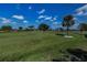 Scenic view of a lush green golf course with mature trees on a sunny day with a blue sky and fluffy clouds at 5061 San Rocco Ct, Punta Gorda, FL 33950