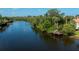 Picturesque view of a serene waterfront with a private dock, lush greenery, and tranquil atmosphere at 5061 San Rocco Ct, Punta Gorda, FL 33950