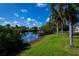 Scenic waterfront view with private dock, lush green landscaping, and tranquil atmosphere at 5061 San Rocco Ct, Punta Gorda, FL 33950