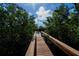 Wooden dock surrounded by lush trees, offering a serene waterfront view with scenic natural beauty at 5061 San Rocco Ct, Punta Gorda, FL 33950
