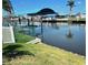 Backyard canal view featuring a boat lift, lush lawn, and waterfront access at 535 Lindley Ter, Port Charlotte, FL 33952