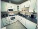 Well-equipped kitchen featuring white cabinetry, granite countertops, and stainless-steel appliances at 535 Lindley Ter, Port Charlotte, FL 33952
